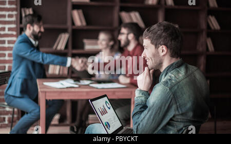 Sales Manager mit einem Notebook, das auf dem Hintergrund der Business Partner h Stockfoto