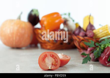 Frisches Gemüse in Weidenkörbe auf dem Holztisch. Stockfoto