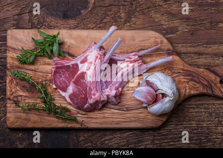 Raw Lammkoteletts mit Kräutern auf Holz Stockfoto
