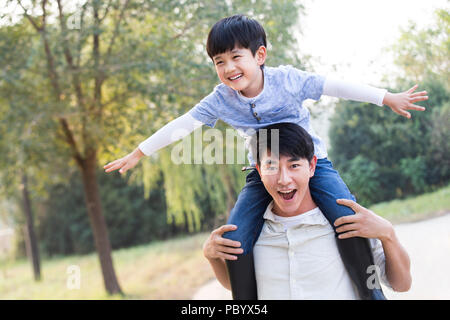 Fröhlicher junger chinesischen Familie spielen im Freien Stockfoto
