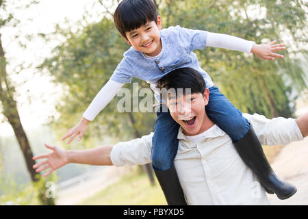 Freundliche chinesische Vater mit Sohn auf den Schultern Stockfoto