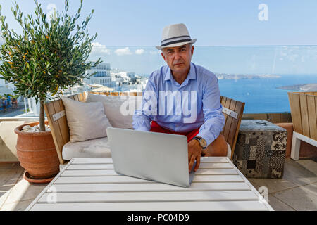 Mann in einem Café am Meer an einem Notebook arbeitet Stockfoto