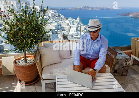 Mann in einem Café am Meer an einem Notebook arbeitet Stockfoto