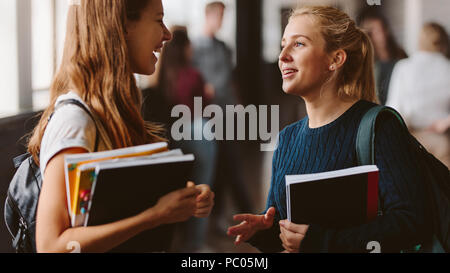 Lächelnde Mädchen in der High School Flur. Zwei weibliche Studenten im Gespräch nach dem Vortrag. Stockfoto