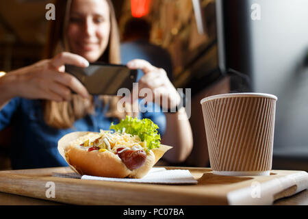 Junge Frau mit Foto von ihr Mittagessen im Cafe Stockfoto