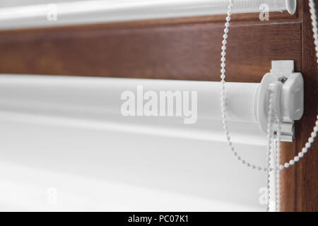 Details der weißen Stoff Rollos an den Kunststoff Fenster mit Holz Textur im Wohnzimmer Stockfoto