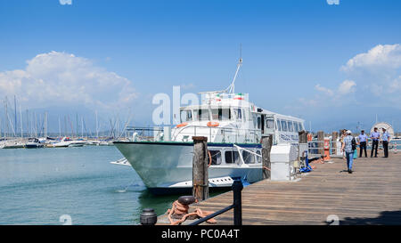 Fähre mit Touristen auf dem Pier in Desenzano del Garda, Italien Stockfoto