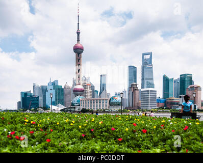 Landschaft Blick auf den Bund (Waitan), Shanghai, mit gelben und roten Blüten im Vordergrund und der Oriental Pearl TV Tower im Hintergrund Stockfoto