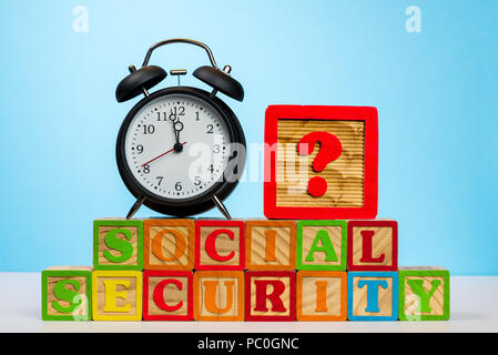 Wecker auf Holzklötze für Soziale Sicherheit Stockfoto