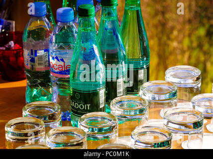 Mineralwasser Flaschen und Gläser auf dem Tisch des Amtes, Stockfoto