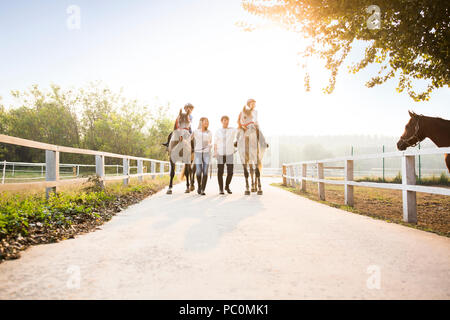 Fröhlicher junger chinesischen Familie reiten pferde Stockfoto