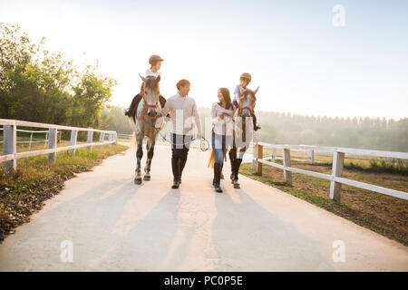 Fröhlicher junger chinesischen Familie reiten pferde Stockfoto