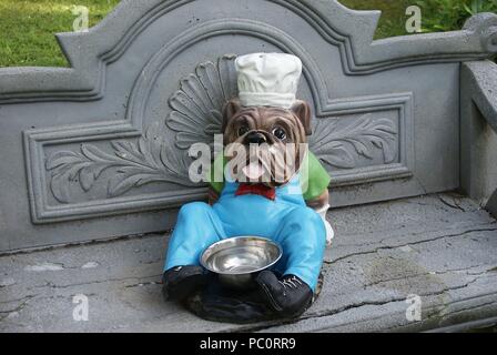 Abbildung einer Englischen Bulldogge mit Wasserabscheidertopf für Hunde auf einer Bank arrangiert Stockfoto