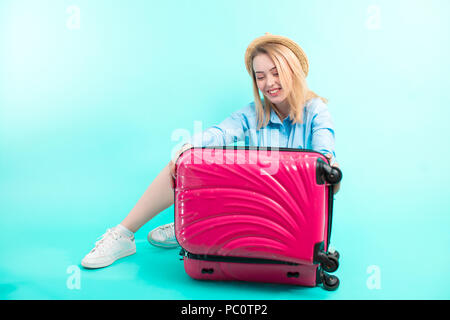 Fröhliches Mädchen wird Ihr Gepäck zu schließen. Holiday-maker Verpackung Kleidung in einen Koffer Stockfoto