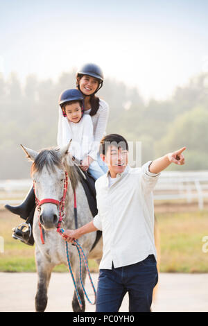 Fröhlicher junger chinesischen Familie Reiten Stockfoto