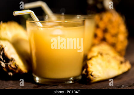 Ananassaft und Scheibe auf einen hölzernen Tisch Stockfoto