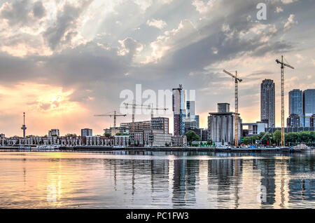 Rotterdam, Niederlande, 16. Juli 2018: Die Sonne über Maashaven Hafen, in dem die modernen Gebäude der Katendrecht und Wilhelminapier spiegeln Stockfoto