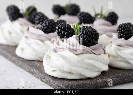 Pavlova Dessert Kuchen mit weichen Lavendel Creme und frische Brombeeren mit Rosmarin Blätter eingerichtet, Ansicht schließen Stockfoto