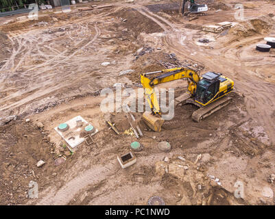 Gelber bagger Maschine arbeiten in Baustelle. Luftaufnahme Stockfoto