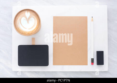 Blick von oben auf die Klammer Tafel, Bleistift, Radiergummi Notepad und Kaffee Tasse auf weißem Marmor und grauem Marmor Tisch stapeln. Flach Mock up Vorlage für Stockfoto