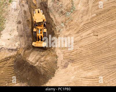 Gelber Bagger entladen Sand auf Baustelle. Antenne Top View Stockfoto
