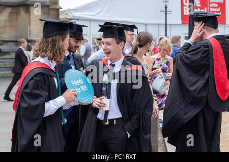 Menge junger Männer feiern Staffelung Holding unterzeichnen, 'Freunde fürs Leben' nach der Abschlussfeier in Bristol, England YK. Stockfoto