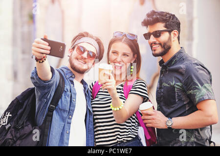 Drei multikulturellen cute besten Freunde in Sonnenbrille lächelnd und unter selfie an der sonnigen Sommer Straße Stockfoto