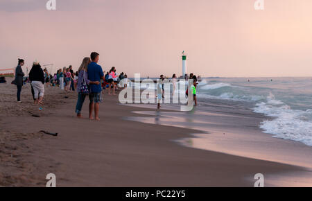 Einen atemberaubenden Sonnenuntergang beginnen unter dem horizion zu gleiten, während die Leute am Strand in Grand Bend sammeln. Stockfoto