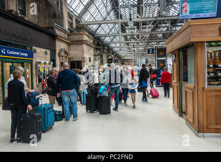 Passagiere queuing Board eine Jungfrau Zug vom Bahnsteig 1 in Glasgow Central Station zu. Zug Reisen, rollenden Gepäck, stehend, wartend in Zeile Stockfoto