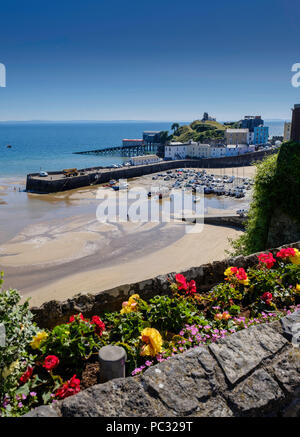 TENBY HAFEN MIT TIDE GOWING, Boote im Hafen und Pkw auf der Hafenmauer. Kabel-Hügel im Hintergrund und Rettungsboot station und Rampe. Stockfoto