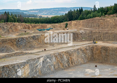 Der Tagebau Steinbruch mit vielen Maschinen. Bergbau in der granitsteinbruch. Arbeiten im Bergbau Maschinen-Digger, Bohrmaschine. Bergbau. Stockfoto