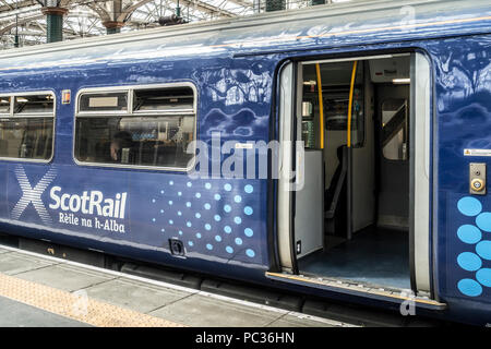 Scotrail Waggon mit Saltire Logo/Branding, mit offener Tür. Passagier sichtbar durch Fenster. Glasgow Central Station, Stockfoto