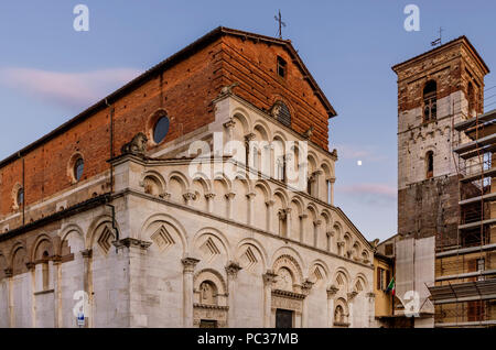 Schöne Sicht auf die antike Kirche Santa Maria Forisportam bei Sonnenuntergang mit dem Mond im Hintergrund, Lucca, Toskana, Italien Stockfoto