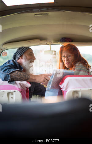 Alte hipster Paar sitzen in einem Van und einem Stadtplan. Stockfoto