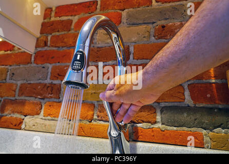 Montreal, Kanada, 31. Juli 2018. Hand einstellen Wasser fließen aus Küche Wasserhahn. Credit Mario Beauregard/Alamy leben Nachrichten Stockfoto