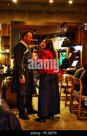 Ukrainische Frau im Gespräch mit dem Georgischen Mann in Circasian Mantel in georgischen Restaurants in Dnipropetrowsk (Dnepr) in der Ukraine auf der Suche nach Aufmerksamkeit und beraten Stockfoto