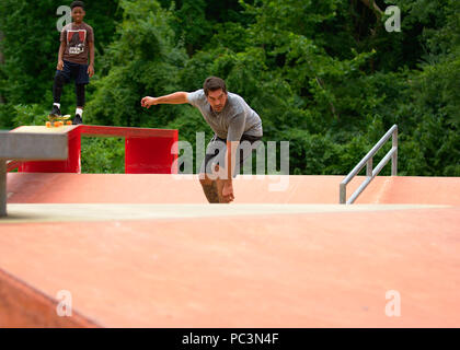 Pre Teen beobachten 30+ nach Skateboarding Stockfoto