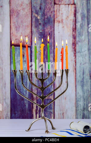 Hanukkah Menorah mit brennenden Kerzen auf holztisch vor alten Vintage Betonwand Urlaub Konzept. Stockfoto