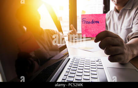 Unternehmer, die Freiheit Wort auf Papier für seine Arbeit und für die gute Arbeit am Tisch quittieren Stockfoto