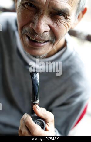 Bahnar (Ba Na) ethnische Gruppe. Portrait des alten Mannes smocking Leitung. Kon Tum. Vietnam. | Verwendung weltweit Stockfoto