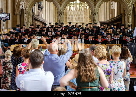 Abschlussfeier in der Kathedrale von Bristol Juli 2018. Absolventen auf der Bühne im Mörser-Boards und Kleider. Familien Fotos Stockfoto