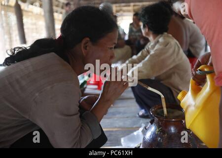 Kommunale Bahnar die ethnischen Minderheiten Rong Haus. Frau trinkt traditionellen Reiswein. Kon Tum. Vietnam. | Verwendung weltweit Stockfoto