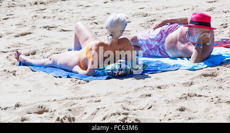 Bournemouth, Dorset, Großbritannien. 31. Juli 2018. UK Wetter: Die Sonne kommt wieder und die Temperaturen steigen, wie Strand - goers Kopf an der Küste des warmen und sonnigen Wetter zu genießen. Reifes Paar Sonnenbaden am Strand. Credit: Carolyn Jenkins/Alamy leben Nachrichten Stockfoto