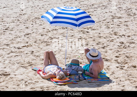 Bournemouth, Dorset, Großbritannien. 31. Juli 2018. UK Wetter: Die Sonne kommt wieder und die Temperaturen steigen, wie Strand - goers Kopf an der Küste des warmen und sonnigen Wetter zu genießen. Senior paar Sonnenbaden am Strand. Credit: Carolyn Jenkins/Alamy leben Nachrichten Stockfoto