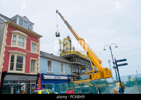 Aberystwyth Wales UK, Mittwoch, 01. August 2018. Nach dem verheerenden Feuer, das den Ty Belgrave House Hotel in Aberystwyth Meer genau vor einer Woche ausgenommen, Arbeiter, die in einer erhöhten Plattform Wiege beginnen die mühsame Aufgabe der demoliting Eine gefährlich beschädigt Schornstein Stein um Stein. Die Struktur hat sicher ist, bevor die Suche durch den Schutt beginnen können für eine vermisste Person, geglaubt, der litauischen, der Verbleib unbekannt ist. Die Polizei hat einen Mann wegen des Verdachts der Brandstiftung mit Absicht, das Leben zu gefährden, verhaftet. Foto © Keith Morris/Alamy leben Nachrichten Stockfoto