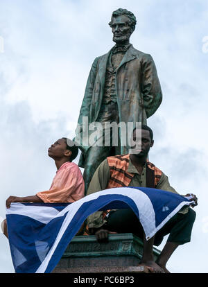 Edinburgh Fringe Festival, Henry Box Brown: Musical Journey Photocall, 1st. August 2018. Edinburgh, Schottland, Großbritannien. Die Besetzung am Abraham Lincoln Memorial, Old Calton Grabstein, das an Schotten erinnert, die im amerikanischen Bürgerkrieg mit der Union gekämpft haben. Ben Harney und der Schriftsteller Mehr Mansuri kreieren das Musical über einen Sklaven aus Virginia aus dem Jahr 1850s. Schwarze amerikanische Schauspieler sitzen zu Füßen von Abraham Lincoln und halten schottischen Saltyre Stockfoto