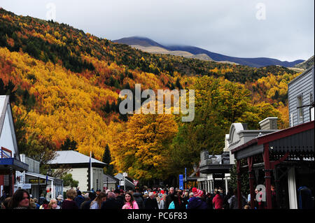 Arrowtown, Neuseeland. 21 Apr, 2018. Die Hauptstraße in Arrowtown auf der Südinsel von Neuseeland - im Hintergrund die Ausläufer der Suedalpen und Wald mit starken Herbst Fleck, im April 2018 | Verwendung der weltweiten Kredit genommen: dpa/Alamy leben Nachrichten Stockfoto