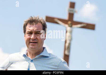 Hausham, Deutschland. 01 Aug, 2018. Markus Soeder, Ministerpräsident von Bayern, steht vor dem Gipfelkreuz in der Nähe der Kreuzbergalm. Wegen der anhaltenden Hitze, in diesem Jahr weniger Menschen nahmen an der jährlichen wichtigsten Alm Inspektion der Alm Management Association. Credit: Lino Mirgeler/dpa/Alamy leben Nachrichten Stockfoto