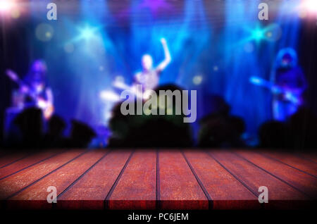 Abstrakt verschwommener Hintergrund.Holztisch oder Theke und Musikband auf der Bühne.Live-Musik Hintergrund. Stockfoto