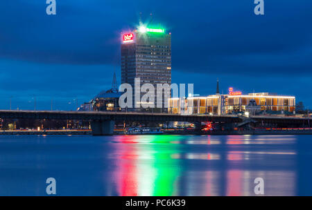 Die Nacht Blick von Riga moderne Gebäude mit herrlichem Wasser Reflexionen in Fluss Daugava Gewässer, Lettland. Stockfoto